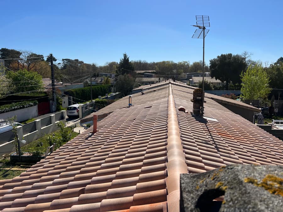 Toiture en tuiles canal refaite sous un ciel bleu en Gironde